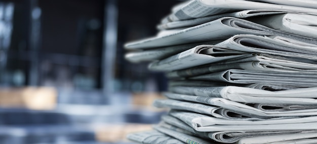 Pile of fresh newspapers on blur background