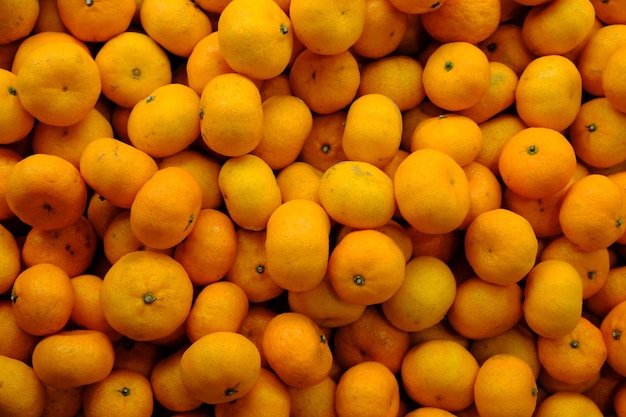 市場で新鮮なオレンジの山。黄色の甘いオレンジ。柑橘類。