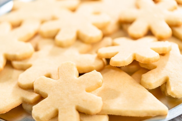 Pile of freshly baked sugar cookies in snowflake shape.