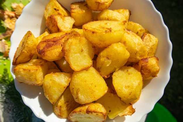 A pile of fried potatoes cut into large slices cut out and isolated on a white background