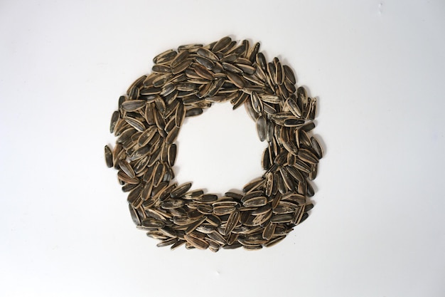 Pile of fried sunflower seeds with circle shape isolated on white background