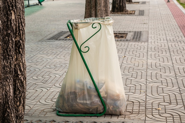 道端にゴミの白い袋のプラスチックを山積み。歩道にゴミ袋。