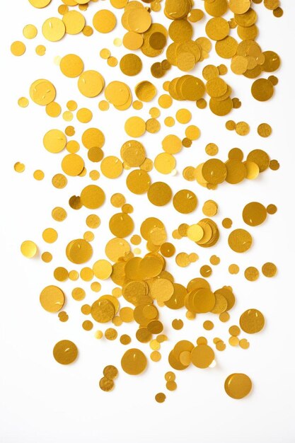 Photo a pile of gold confetti dots on a white background