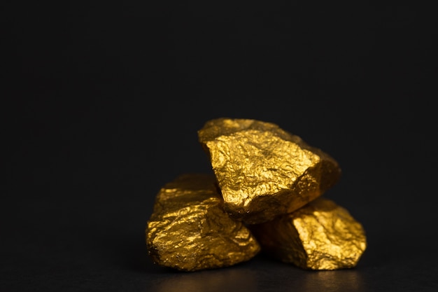金ナゲットや黒の背景に金の鉱石の山