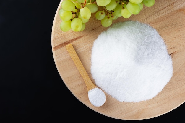 Photo pile of grape sugar or glucose on a wooden board
