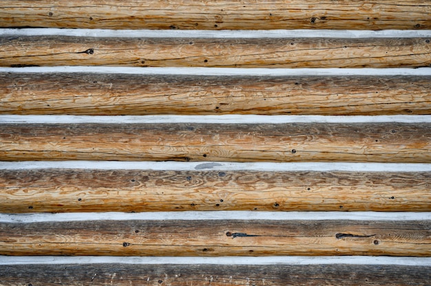 Pile hardwood log with snow in groove. pattern background