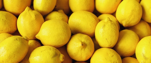 Куча кучи лимонов на продуктовом фруктовом киоске фермерского рынка