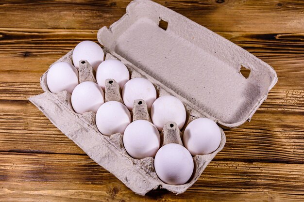 Pile of the hen eggs in paper tray on wooden table