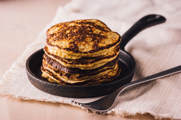 Pile of homemade pancakes freshly made on a small pan, ready to eat