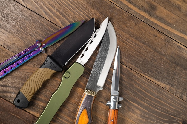 A pile of hunting knives on a table