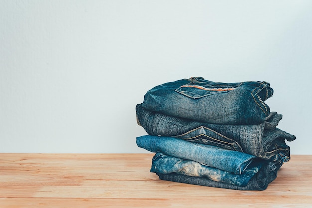 Photo pile of jeans on a wooden background