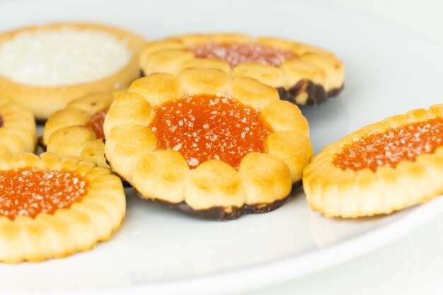 A pile of little fruit tarts on a white plate