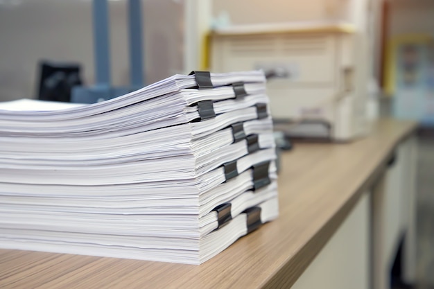 机のオフィスにたくさんの紙や書類のレポートの山。