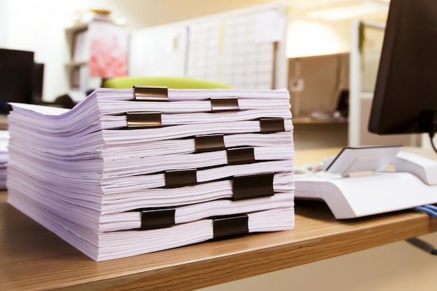 Pile of a lots paperwork report or printout document on desk office stacked.