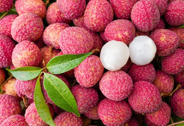 Foto un mucchio di frutti di litchi con plastica bianca in cima.