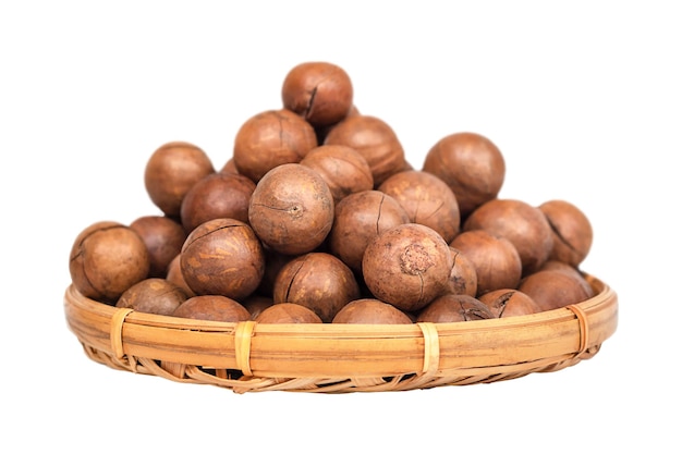 A pile of macadamia nuts in a basket isolated on a white background