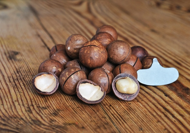 A pile of macadamia nuts on a wooden surface