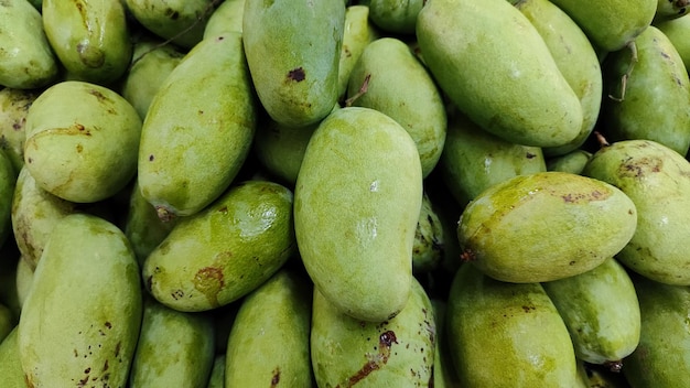 Foto pila di frutti di mango sullo scaffale del supermercato
