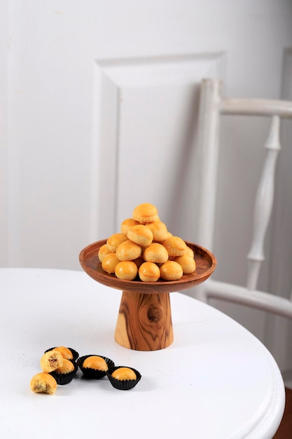 A Pile of Nastar or Ananas Taartjes or Pineapple Tart, Most Popular Various of Kue Kering Lebaran, Usually Served During Hari Raya. Wooden Background with Negative Space.