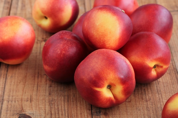 A pile of nectarines on a wooden table