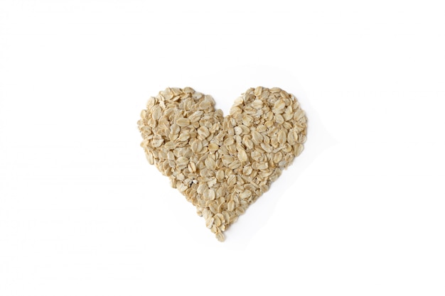 Pile of oatmeal in heart shape isolated on white background