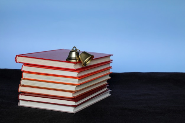 Фото Куча книг и яблоко на вершине на синем фоне