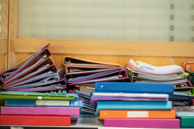 写真 木製の机の上にカラフルなクリップで財務書類の山