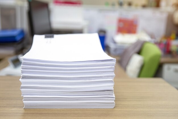 Pile of paper on office desk.