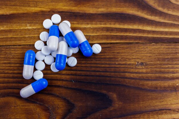 Pile of pills on the wooden background