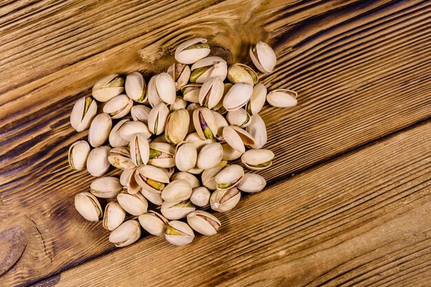 Pile of pistachio nuts on a wooden table