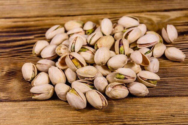 Pile of pistachio nuts on a wooden table