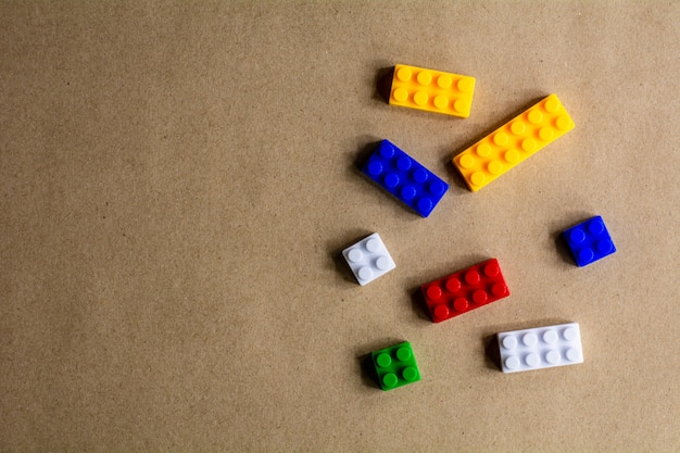 Pile of plastic building blocks on brown paper background