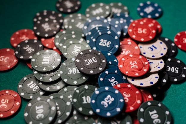 Pile of poker chips on a green table close up