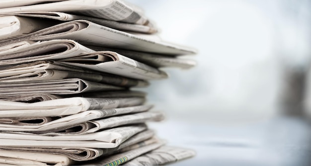 Pile of printed newspapers on background