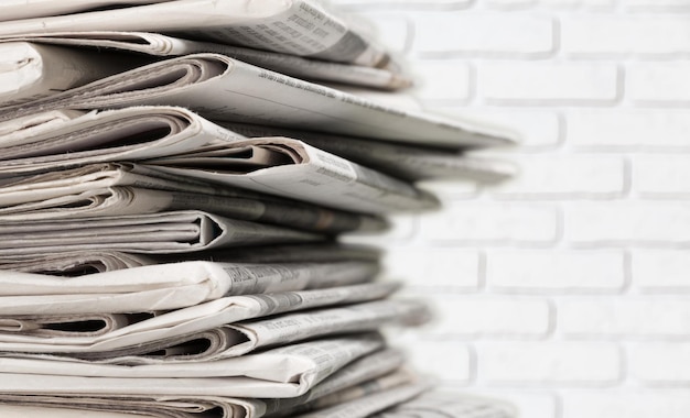 Pile of printed newspapers on background