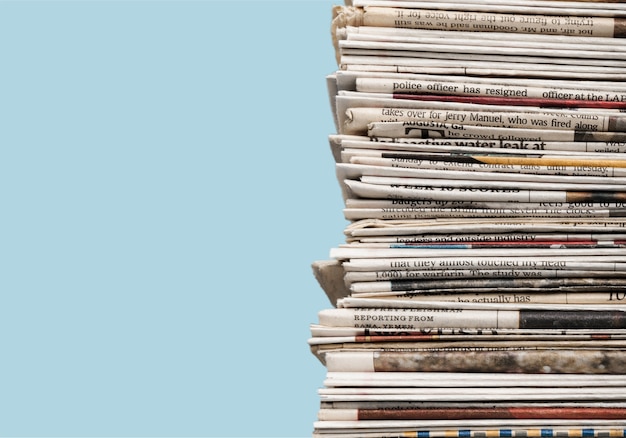 Pile of printed newspapers on blue background