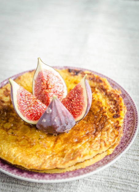 Pile of pumpkin crepes decorated with fresh fig