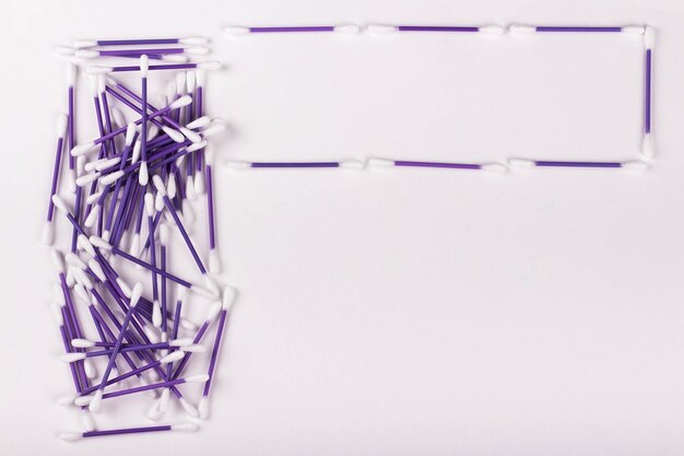 Pile of purple cotton buds on white background copy space