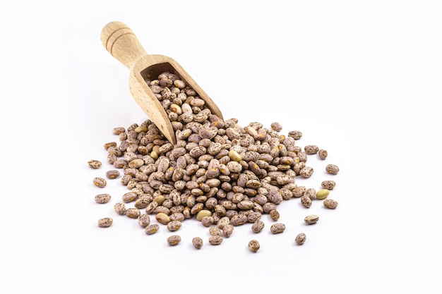 Pile of Rajado beans, brazilian beans, with wooden measuring spoon, copy space