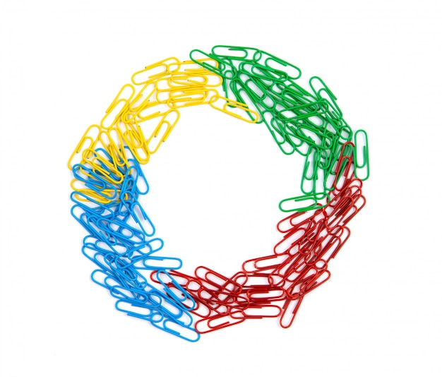 Photo a pile of red, green, blue and yellow paper clips lies in the center of the sheet