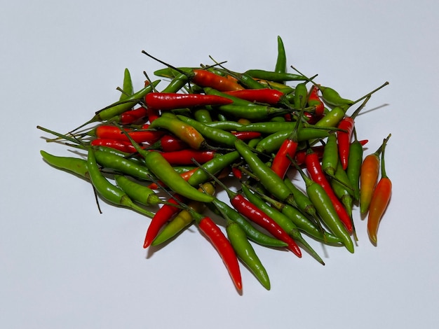 A pile of red and green chili peppers on isolated background