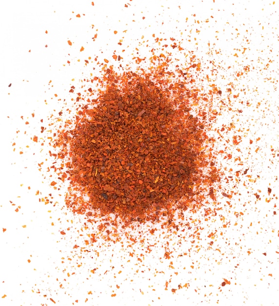 Photo pile of red paprika powder on white wall