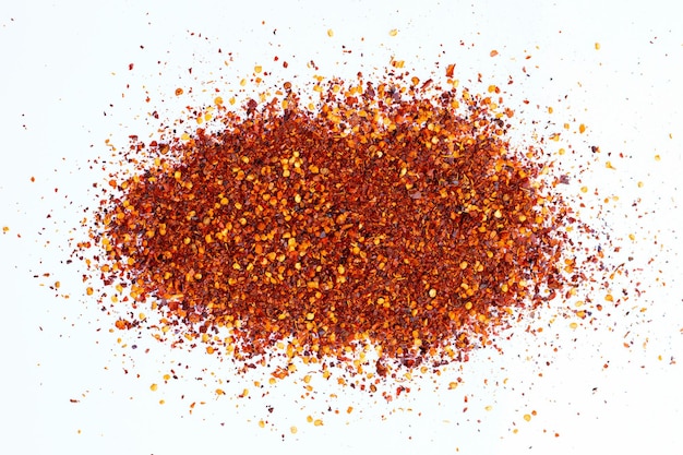 Pile of red pepper flakes on a white background