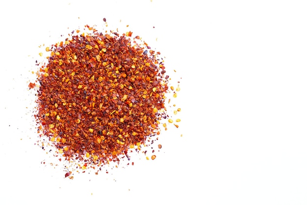 Pile of red pepper flakes on a white background