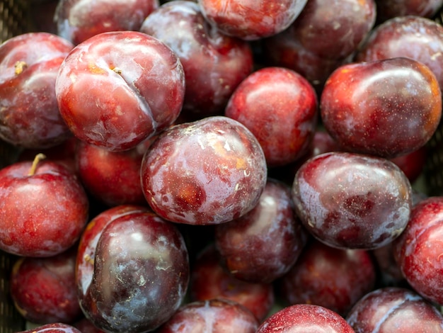 A pile of red plum fruits Prunus americana in the supermarket