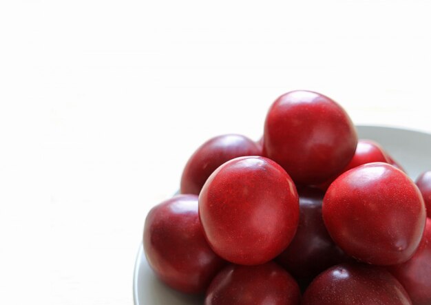 Pile of Ripe Gulf Ruby Plum Fruits on Plate 