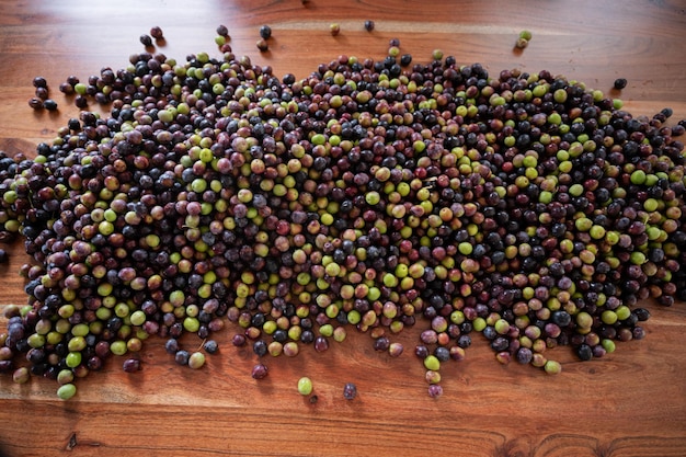 Pile of ripe olives on a wooden desk