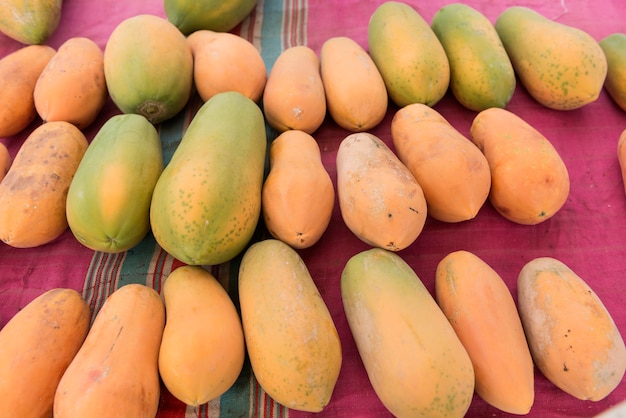 Куча спелых желтых папайи для продажи на рынке.