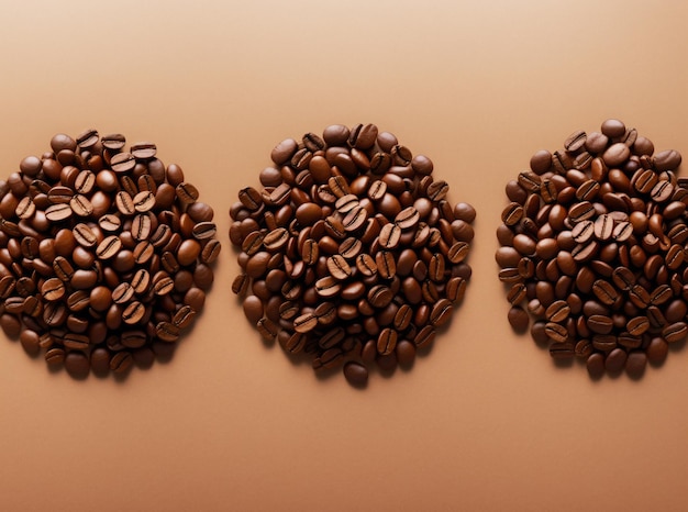 Pile of roasted coffee beans on a brown background