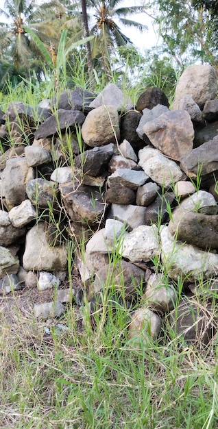 Photo a pile of rocks is stacked on top of a hill.